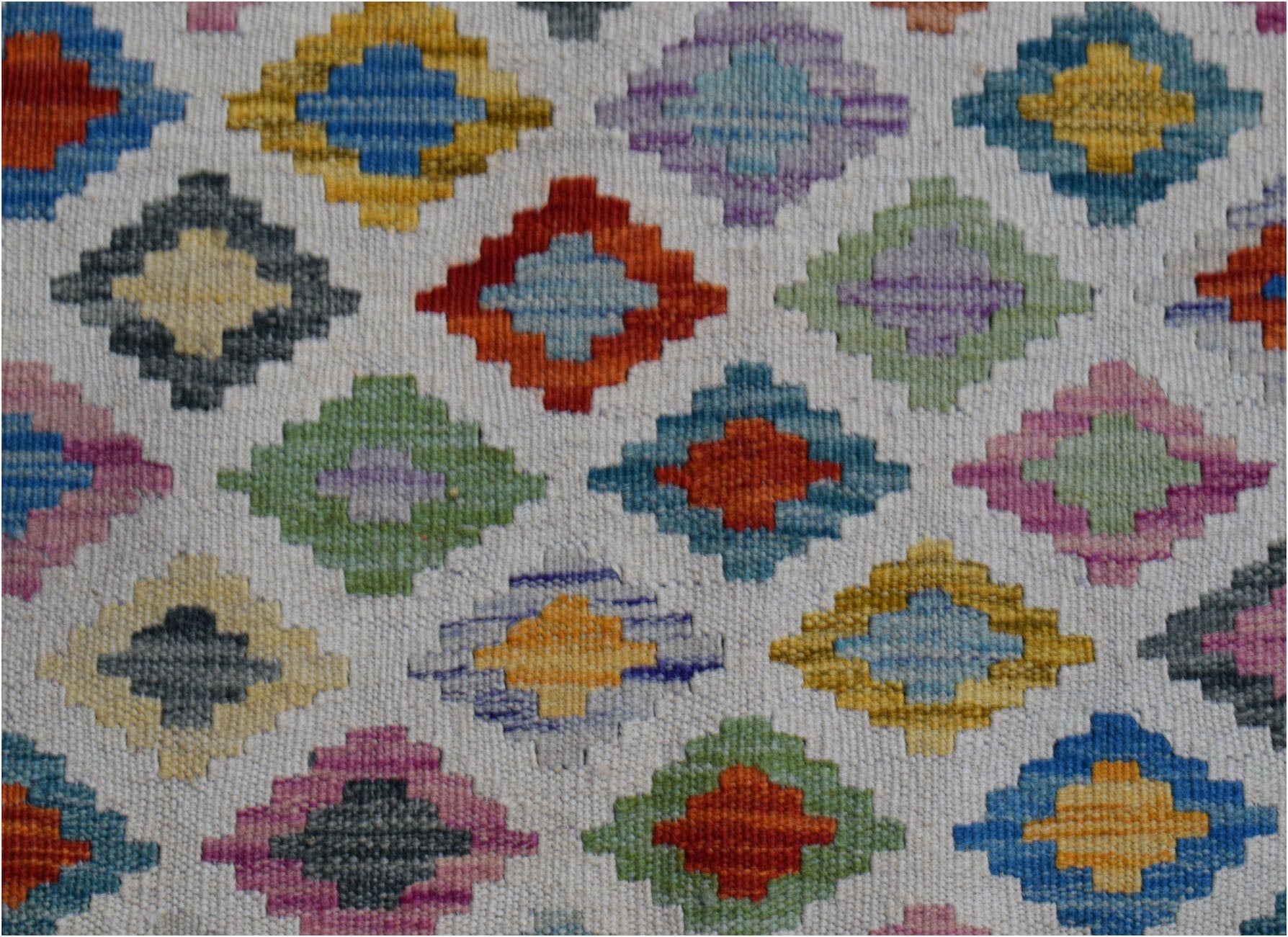 Handwoven Afghan Maimana wool kilim runner featuring a repeating pattern of colorful diamonds.