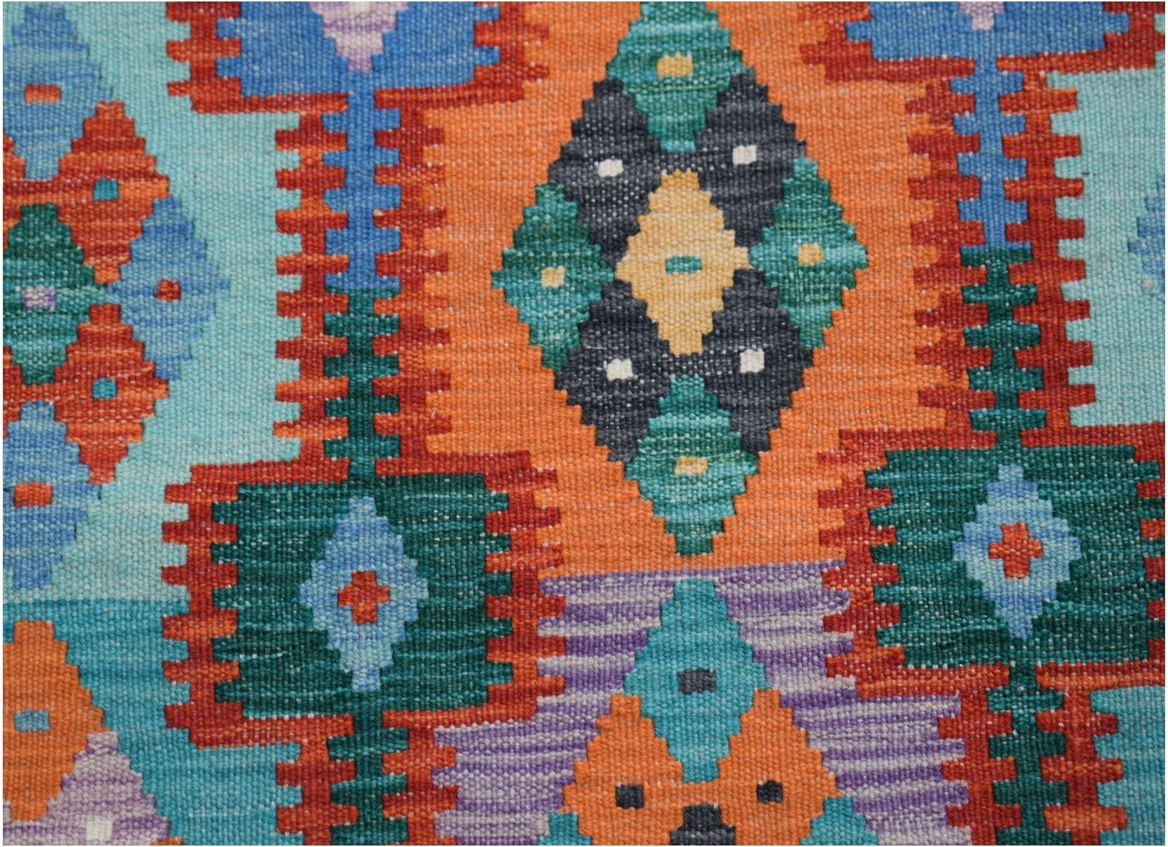 Handwoven Afghan Maimana kilim runner featuring a vibrant geometric pattern in wool.