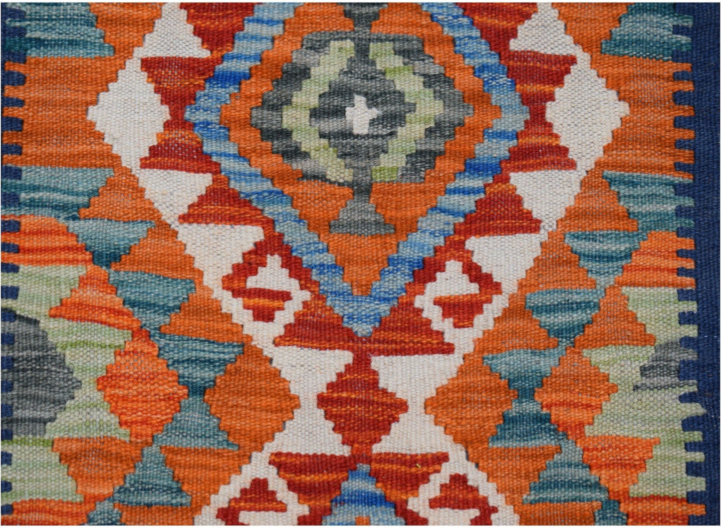 Handwoven Afghan Maimana wool runner featuring a vibrant geometric pattern in orange and blue.