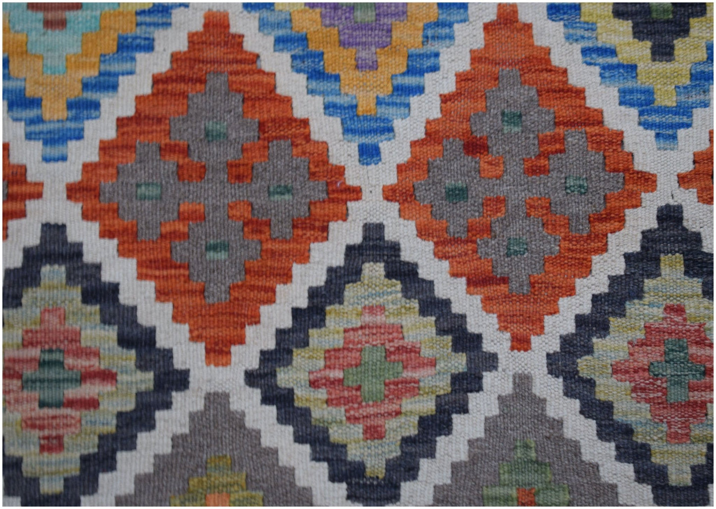 Handwoven Afghan Maimana kilim runner featuring a geometric diamond pattern in vibrant colors.