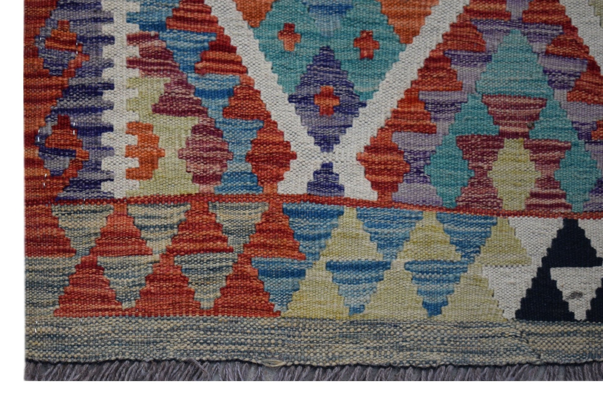 Handwoven Afghan Maimana kilim runner featuring a vibrant geometric pattern in wool.
