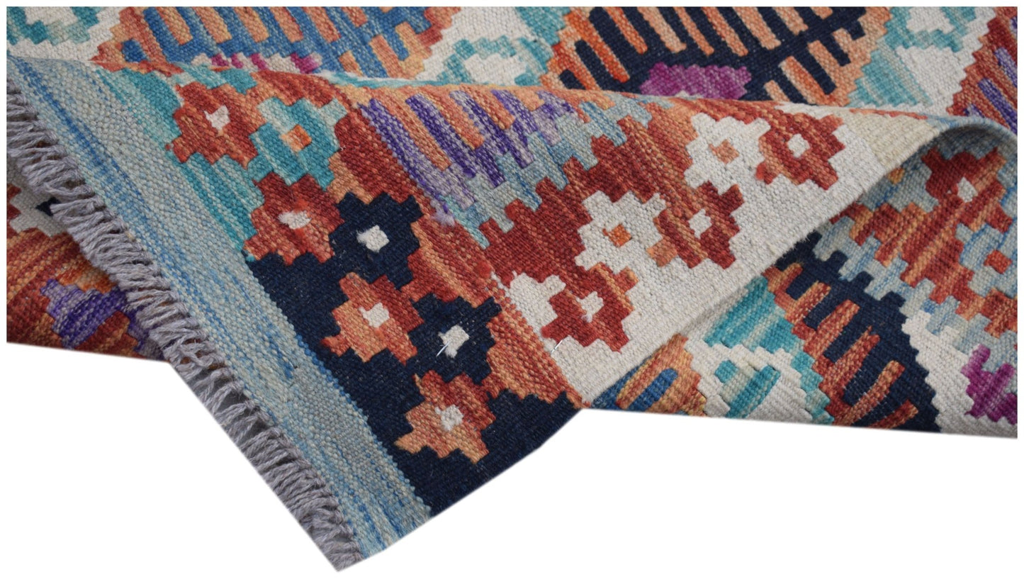 A handmade Afghan Maimana kilim runner featuring a vibrant geometric pattern in wool.