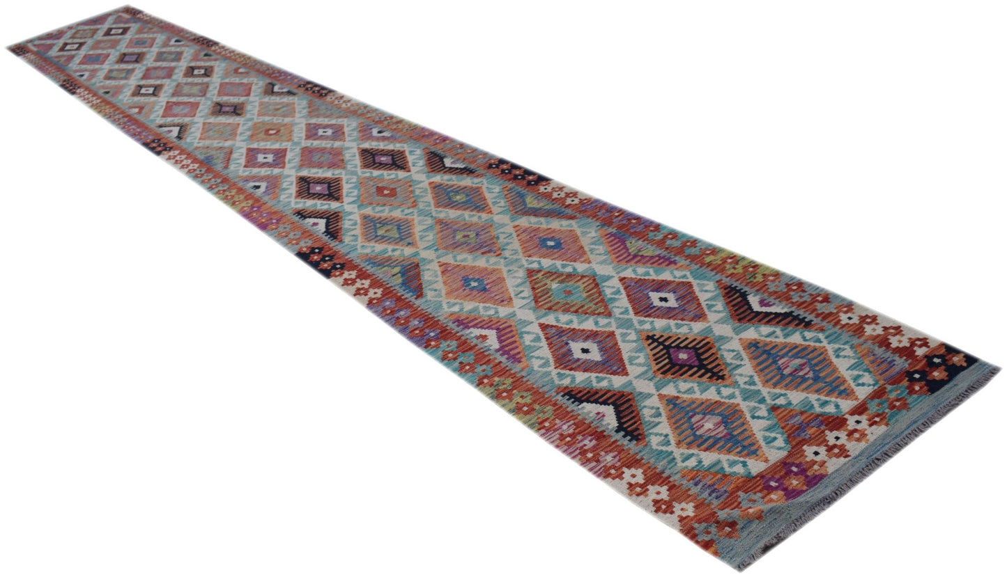 A long, handmade Afghan Maimana Kilim runner featuring a colorful geometric diamond pattern.