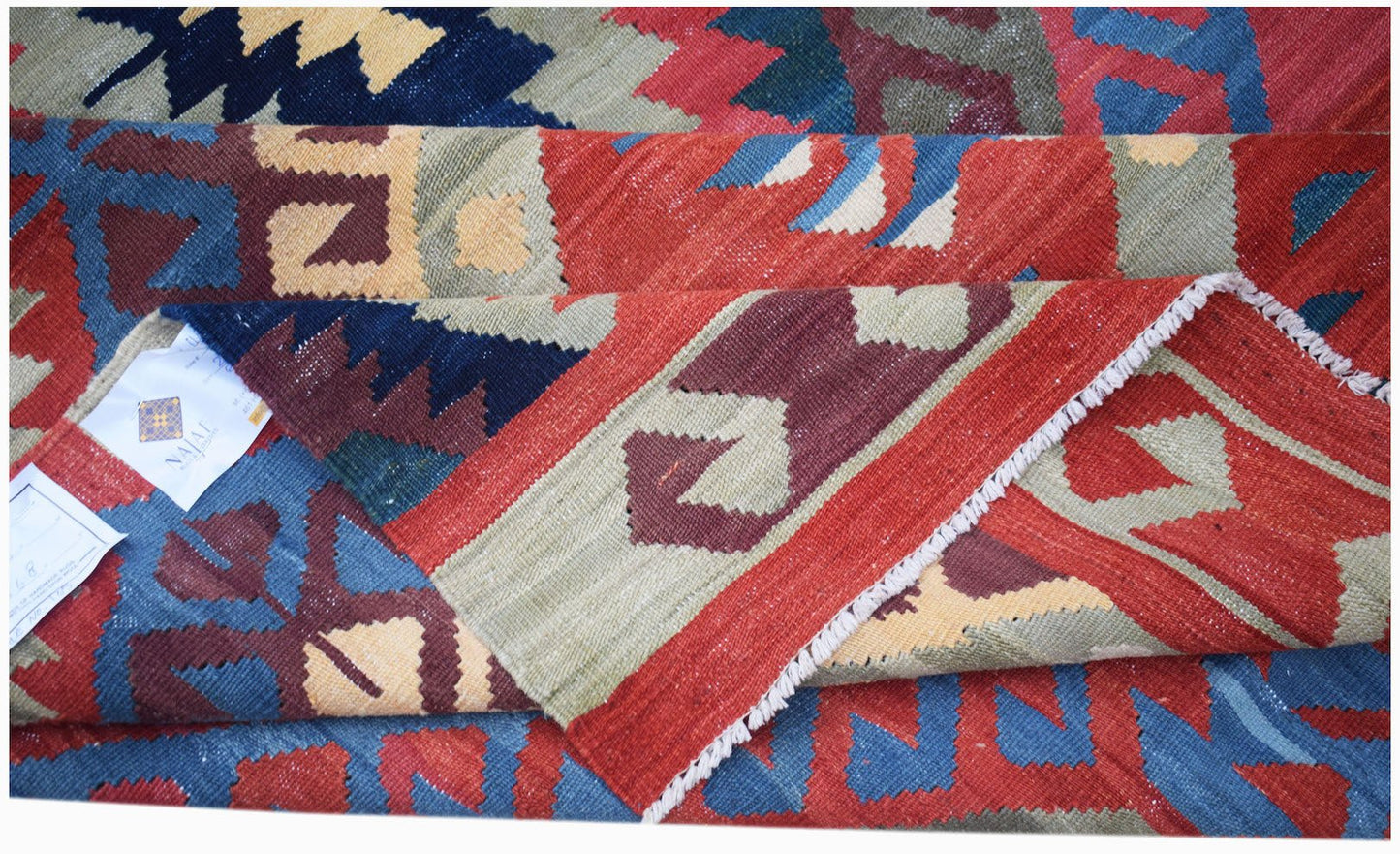 Handwoven Afghan Mazari Sharif kilim featuring a geometric pattern in red, blue, and tan wool.