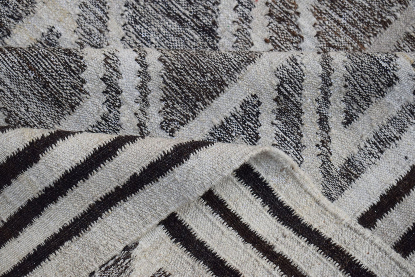 A handmade Afghan Maimana kilim rug featuring a geometric pattern in natural wool.