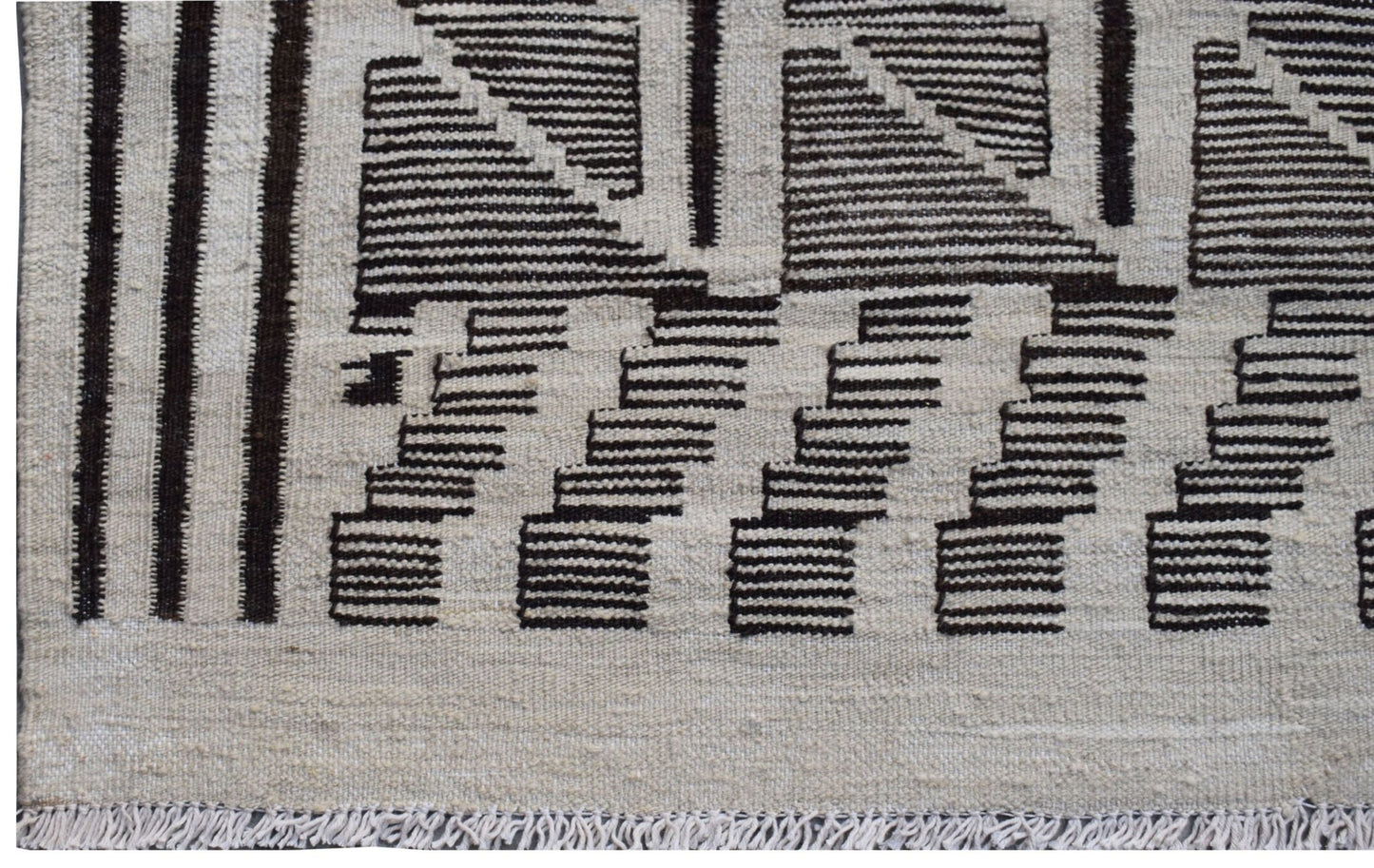 Handmade Afghan Maimana kilim rug featuring a geometric pattern in black and natural wool tones.