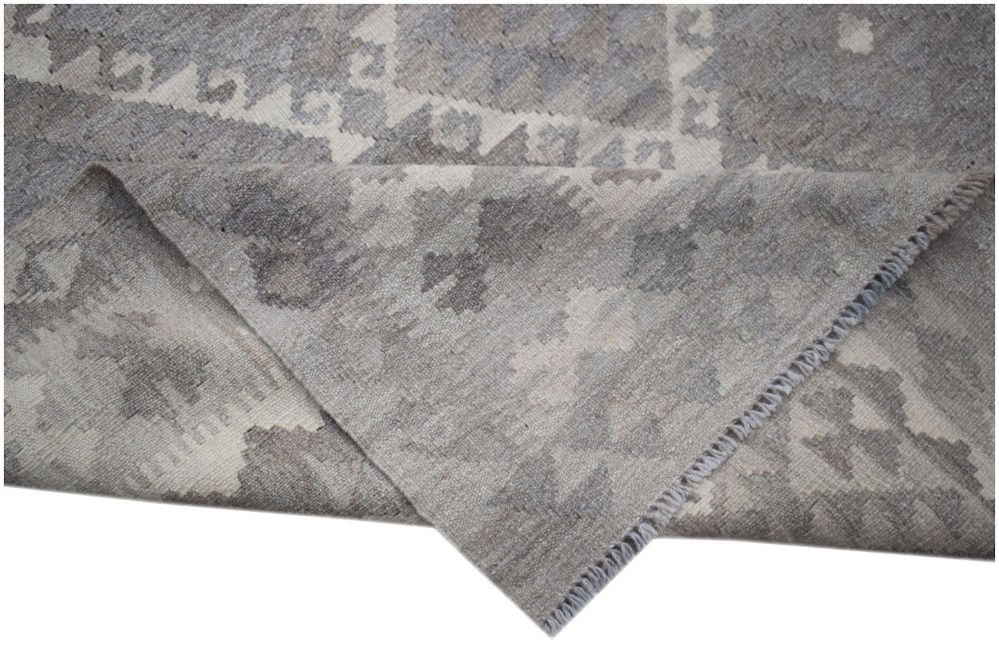 A handwoven Afghan Maimana kilim rug featuring a grey and white geometric pattern.