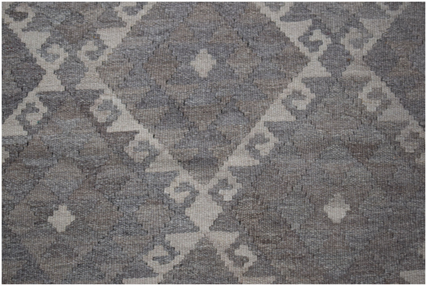 Handwoven Afghan Maiamana kilim featuring a geometric diamond pattern in natural wool tones.