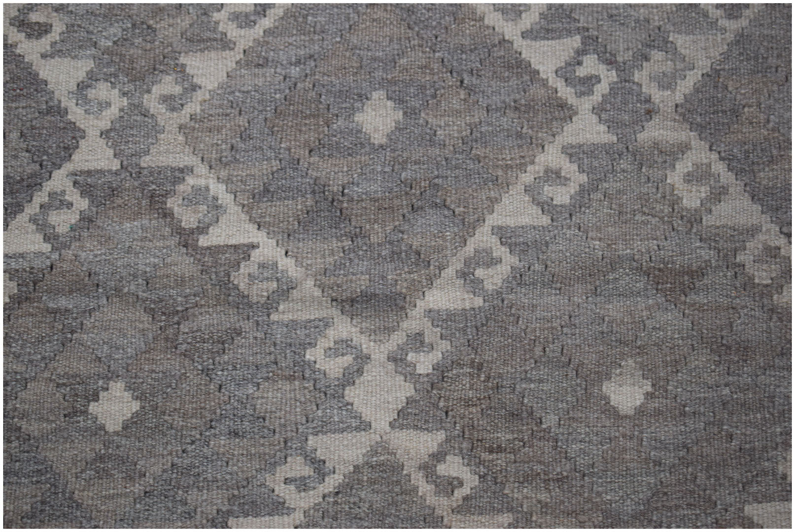 Handwoven Afghan Maiamana kilim featuring a geometric diamond pattern in natural wool tones.