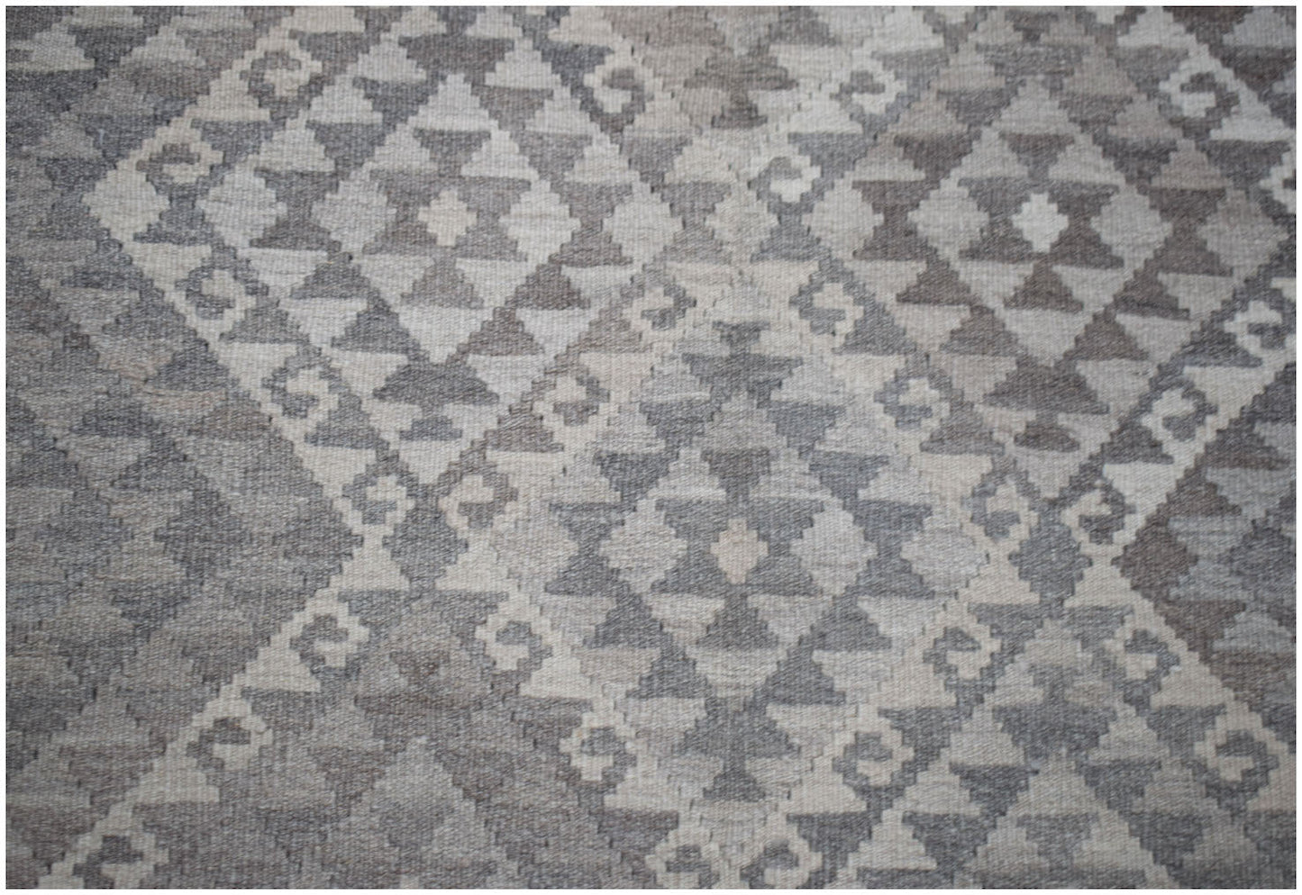 Handwoven Afghan Maimana kilim rug featuring a geometric diamond pattern in natural wool tones.