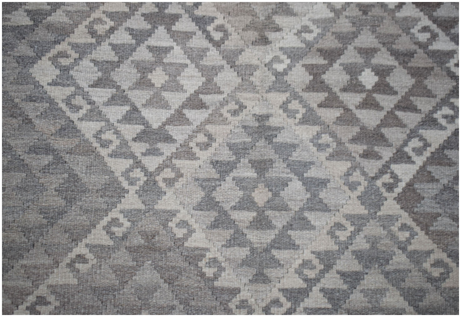 Handwoven Afghan Maimana kilim rug featuring a geometric diamond pattern in natural wool tones.
