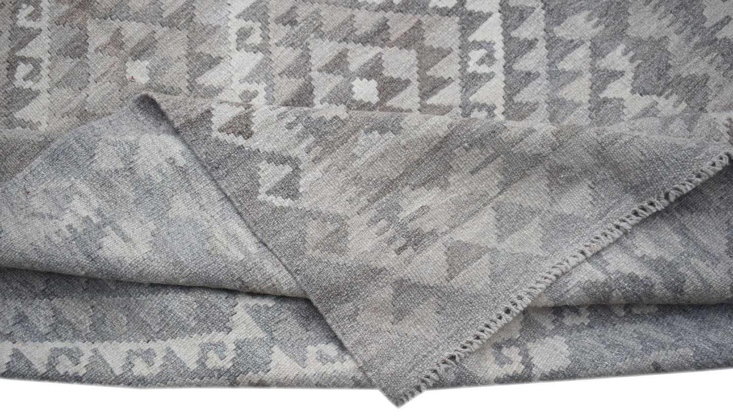 A handwoven Afghan Maimana kilim rug featuring a grey and white geometric pattern.