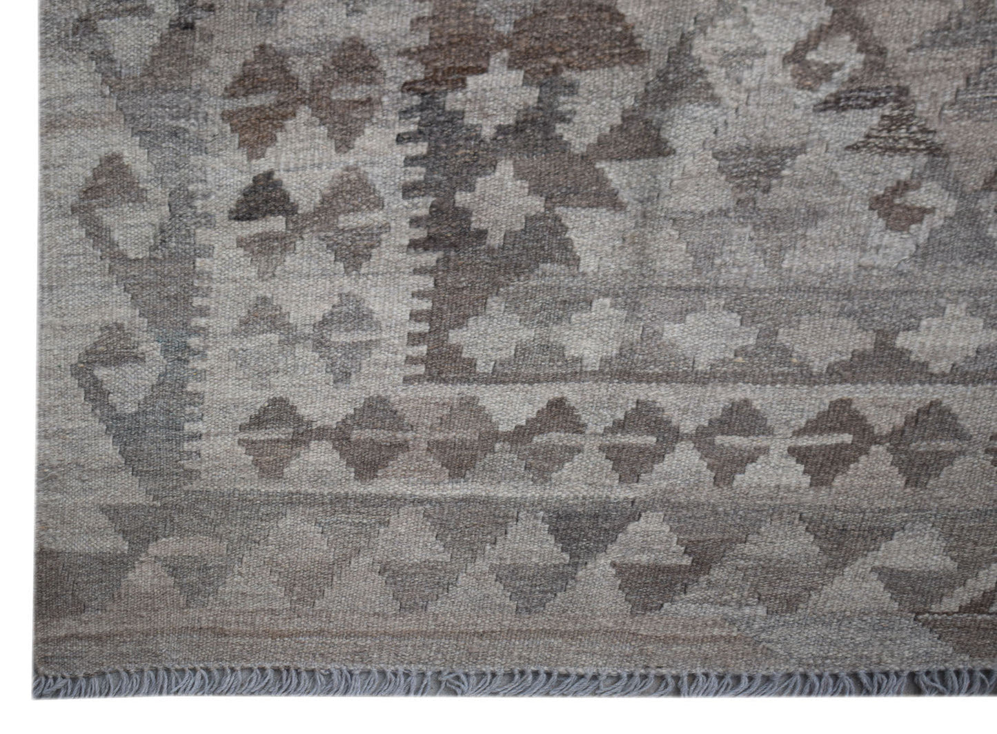 Handwoven Afghan Maiamana kilim rug featuring a geometric pattern in shades of grey and brown.