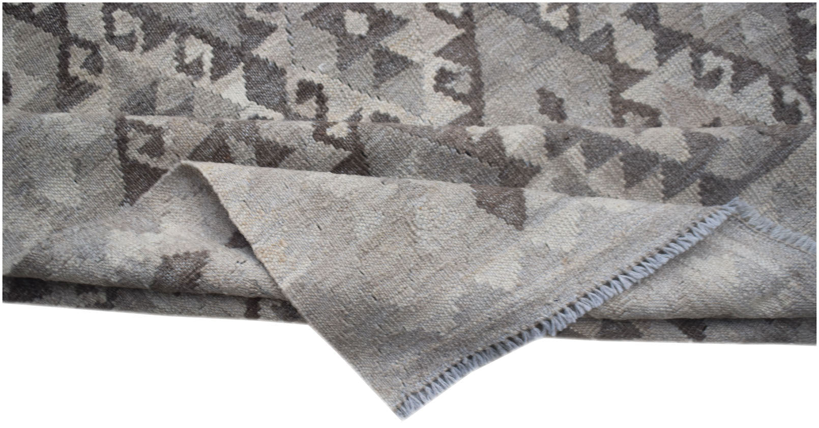 A handwoven Afghan Maimana kilim rug featuring a geometric pattern in undyed natural wool.