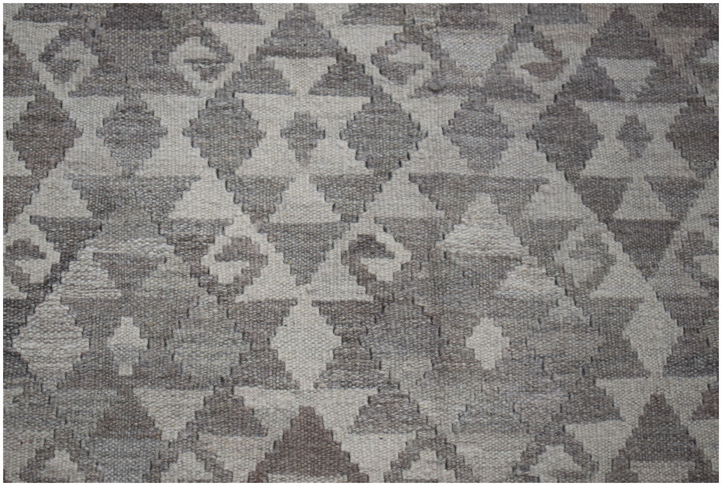 Handwoven Afghan Maimana kilim rug featuring a geometric diamond pattern in natural wool tones.