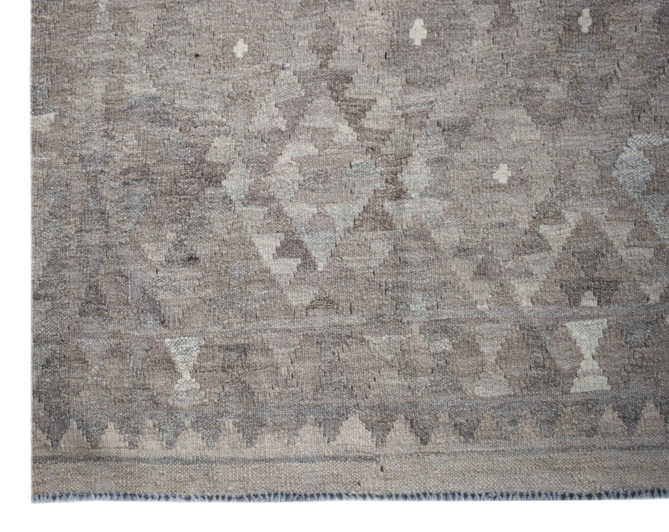 Handwoven Afghan Maimana kilim rug featuring a geometric pattern in neutral grey tones.