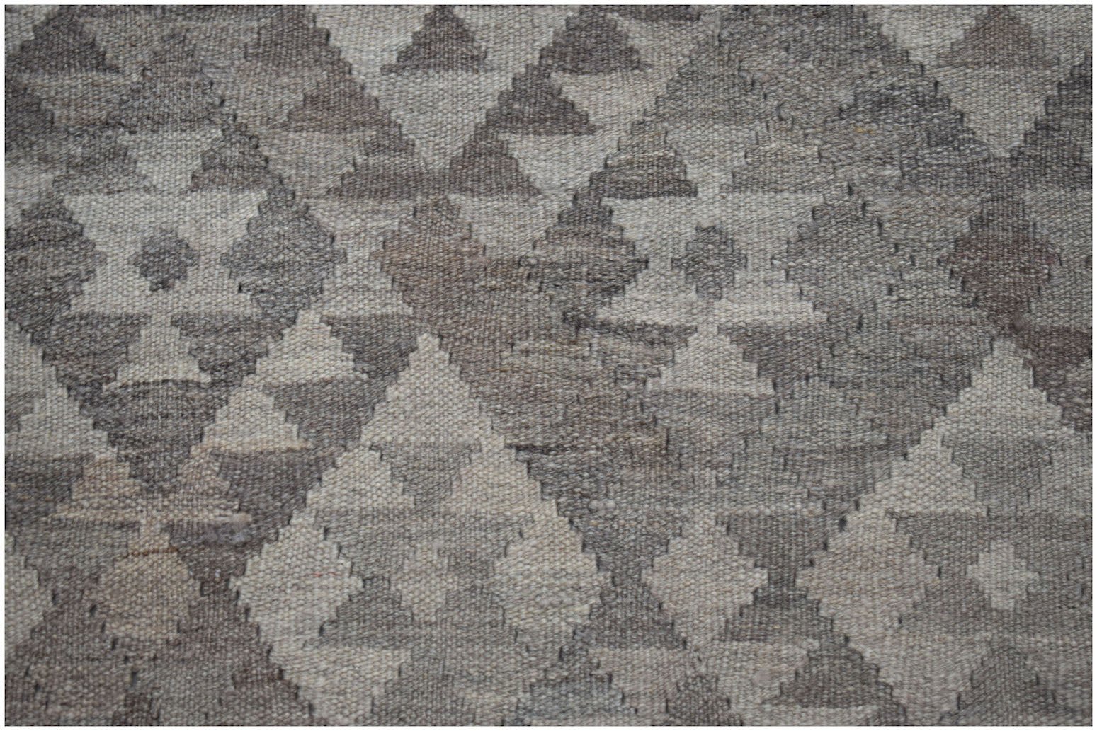 Handwoven Afghan Maiamana kilim featuring a geometric diamond pattern in natural wool tones.