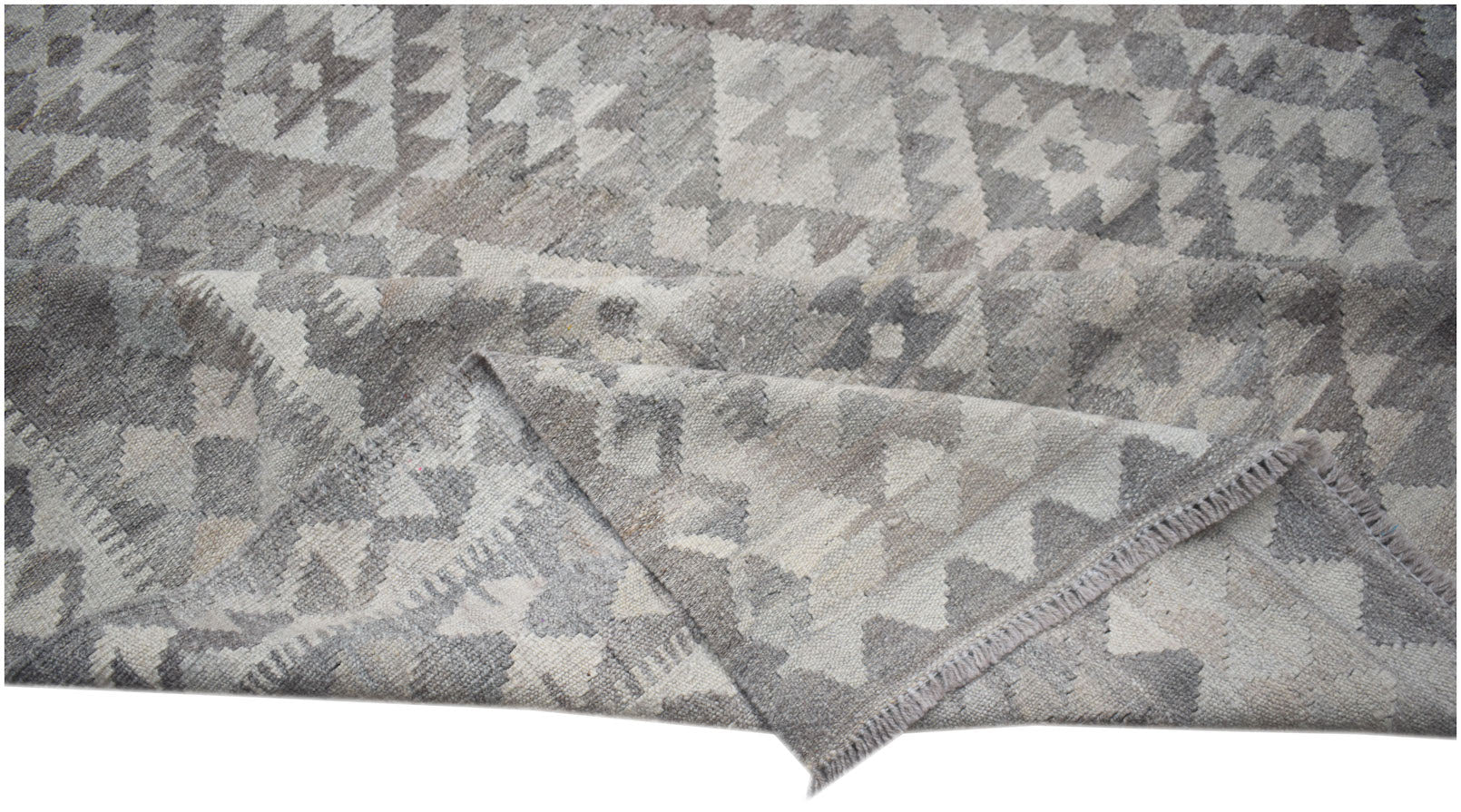 A handwoven Afghan Maimana kilim rug featuring a geometric pattern in shades of grey and white.