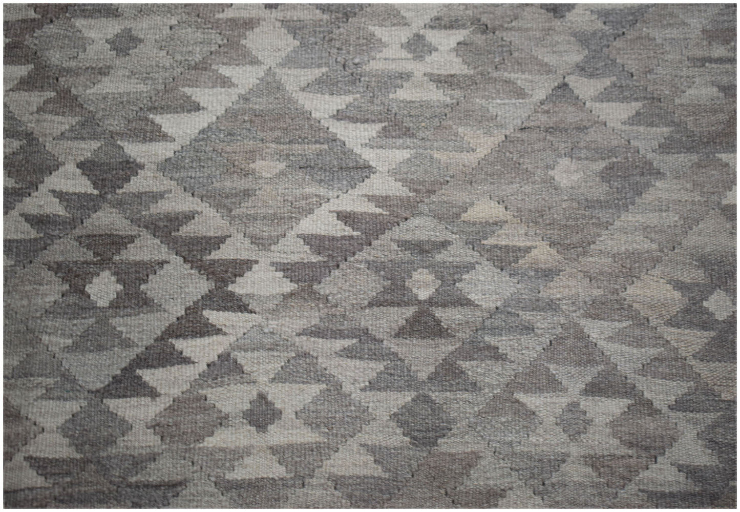 Handwoven Afghan Maiamana kilim rug featuring a geometric diamond pattern in natural wool tones.
