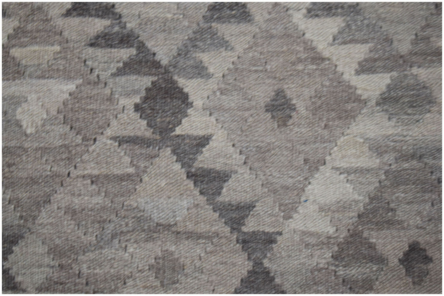 A handwoven Afghan Maimana kilim featuring a geometric diamond pattern in shades of grey and white.
