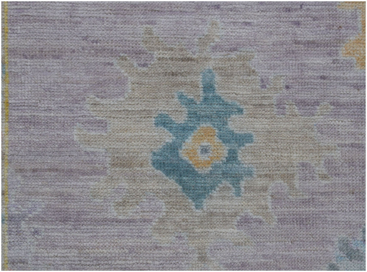 A handmade Afghan Oushak runner featuring a traditional floral motif in blue, yellow, and lavender.