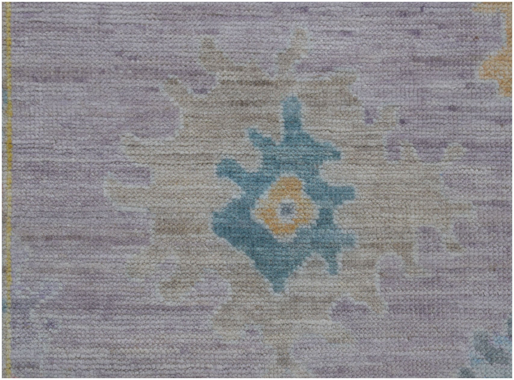 A handmade Afghan Oushak runner featuring a traditional floral motif in blue, yellow, and lavender.