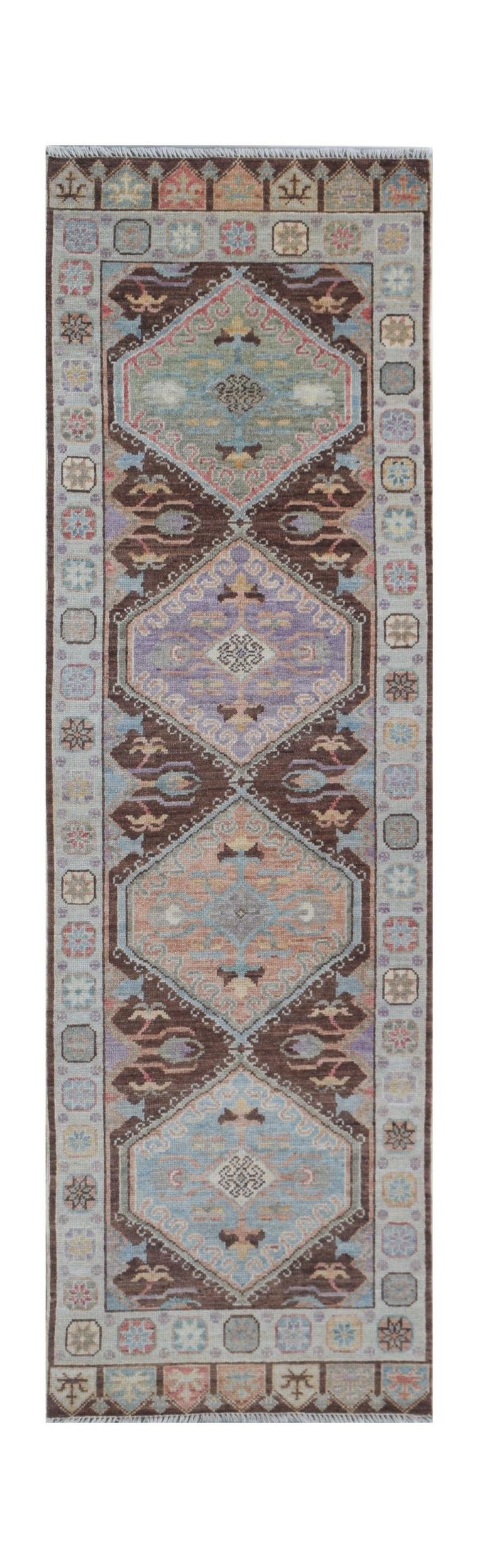 A handmade Afghan Oushak runner featuring a traditional geometric pattern in soft pastel tones.