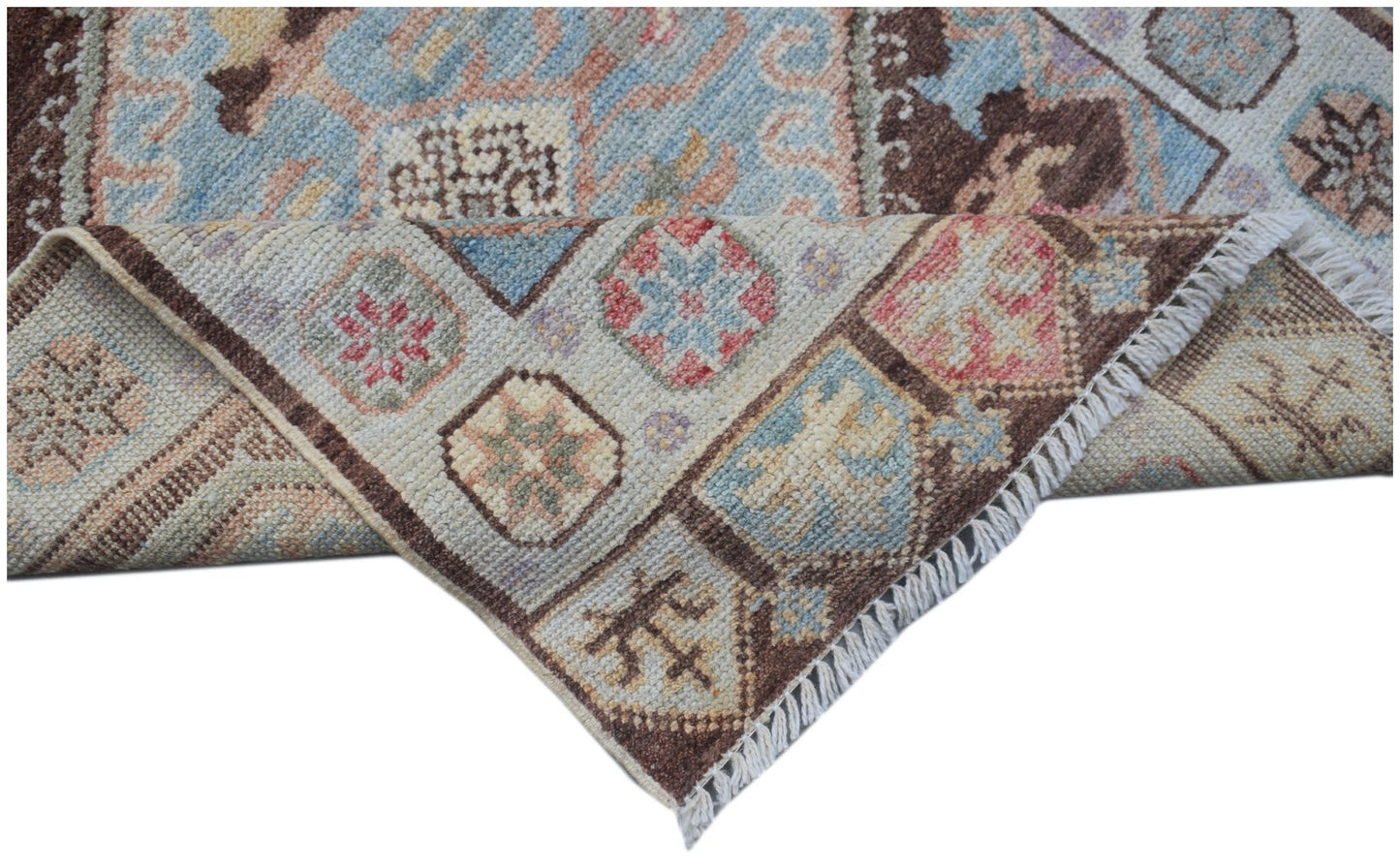 A handmade Afghan Oushak runner featuring a traditional geometric pattern in soft pastel tones.