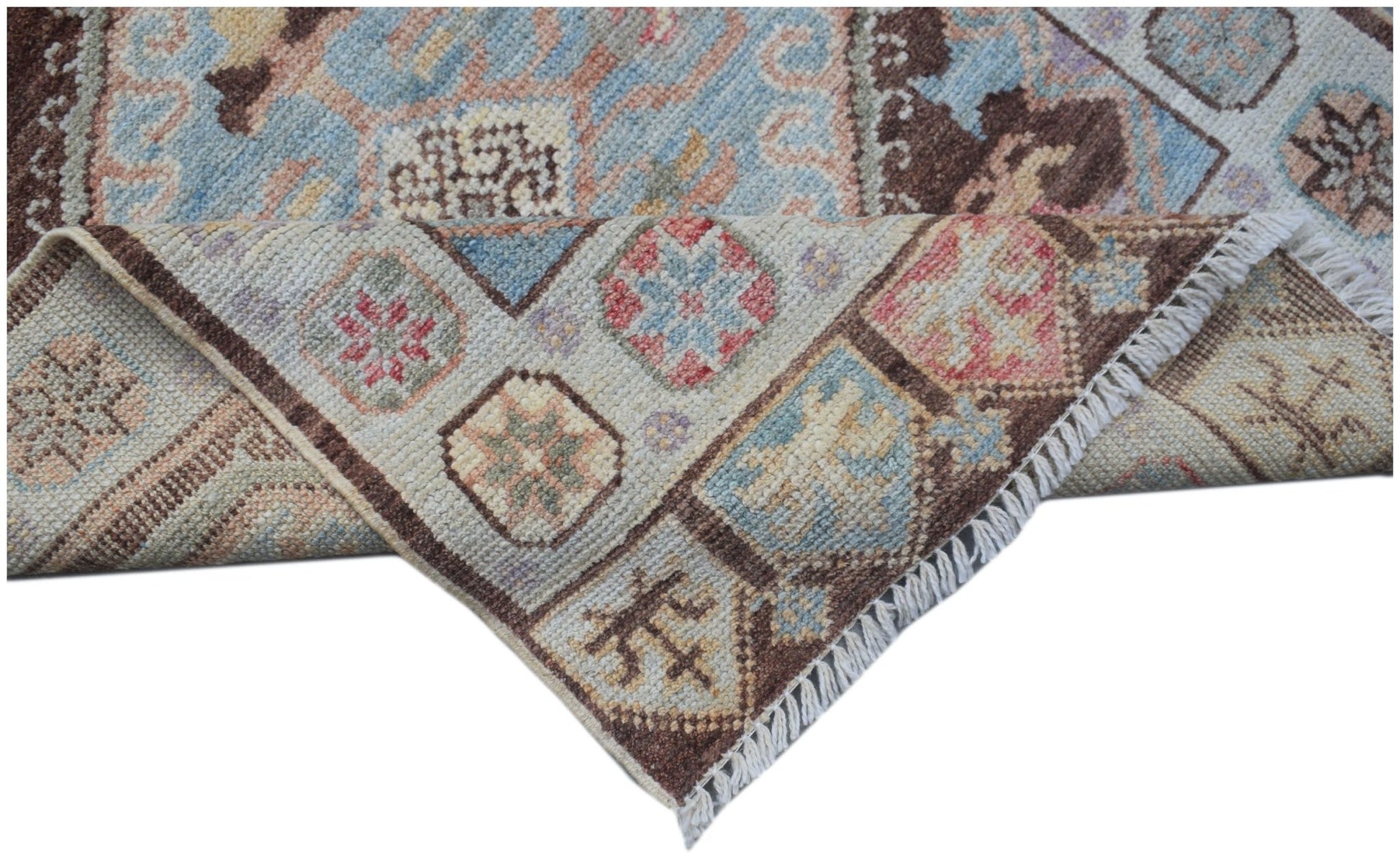 A handmade Afghan Oushak runner featuring a traditional geometric pattern in soft pastel tones.