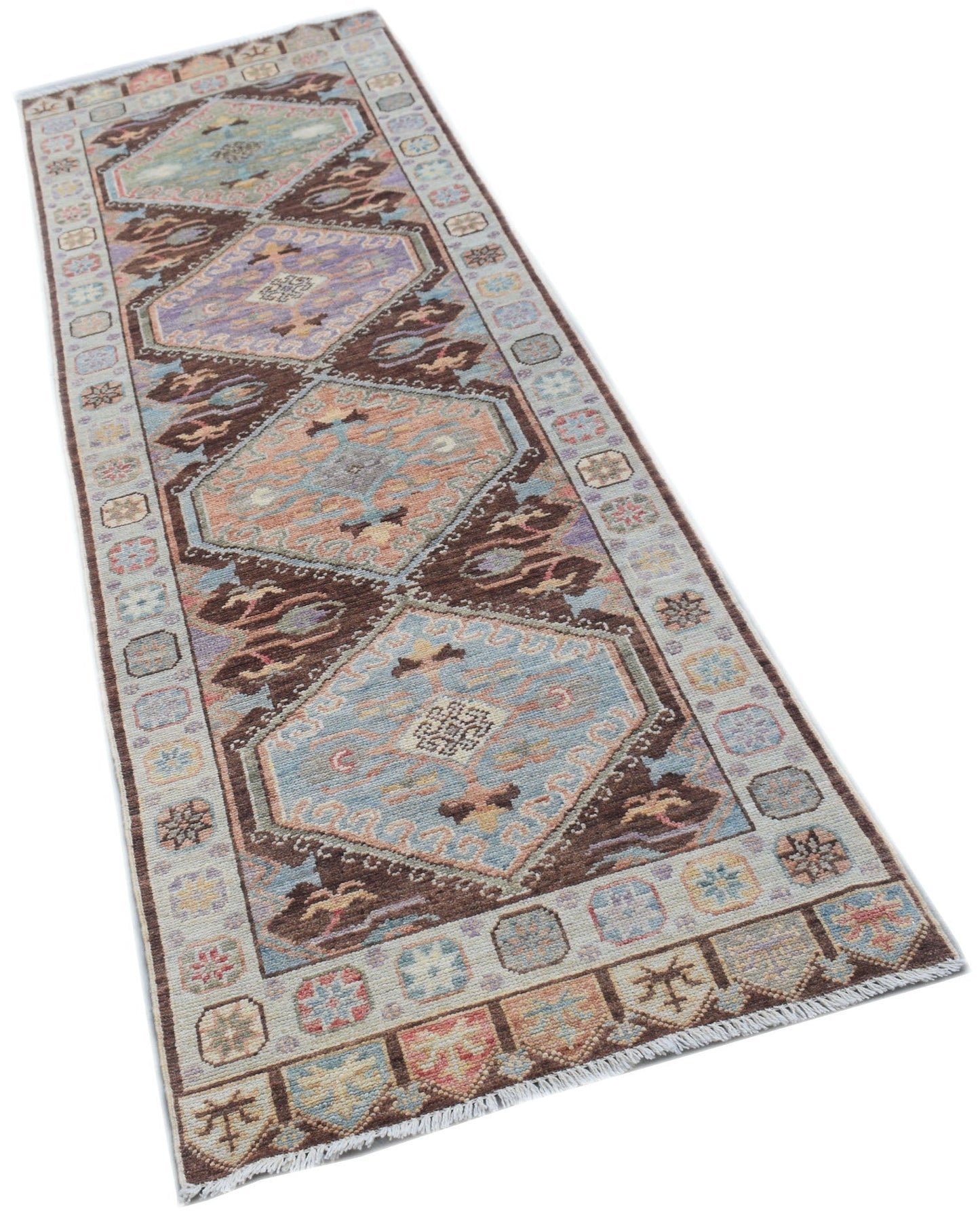 A handmade Afghan Oushak runner rug featuring a traditional geometric pattern in muted colors.
