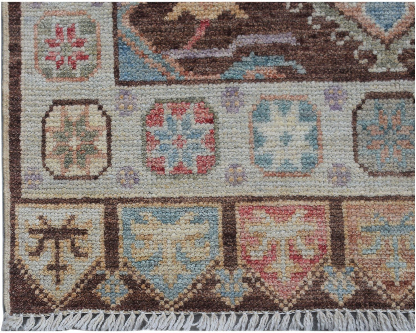 A handmade Afghan Oushak runner featuring a traditional geometric pattern in soft pastel tones.