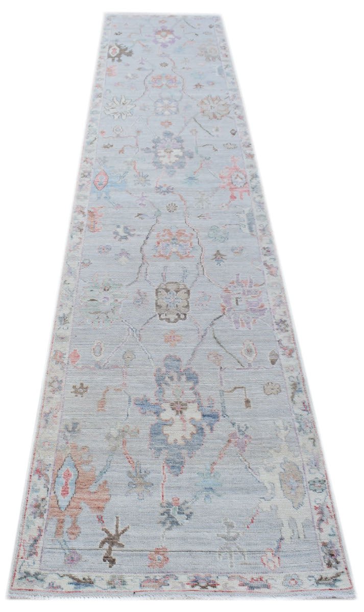 A handmade Afghan Oushak runner rug featuring a traditional floral pattern in soft pastel tones.