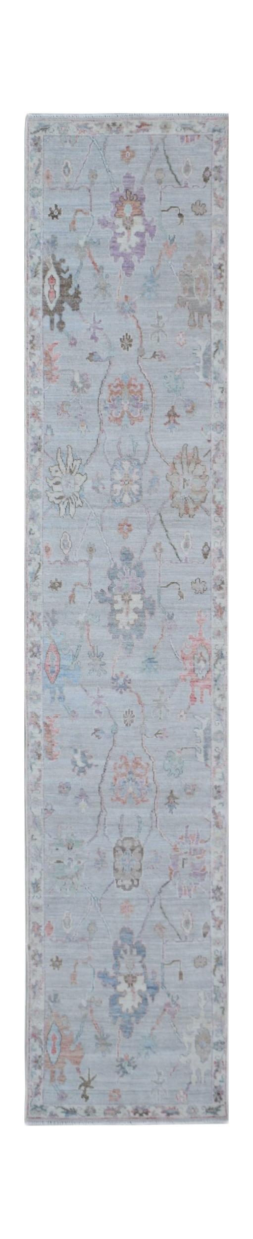 A handmade Afghan Oushak runner rug featuring a traditional floral pattern in soft pastel tones.