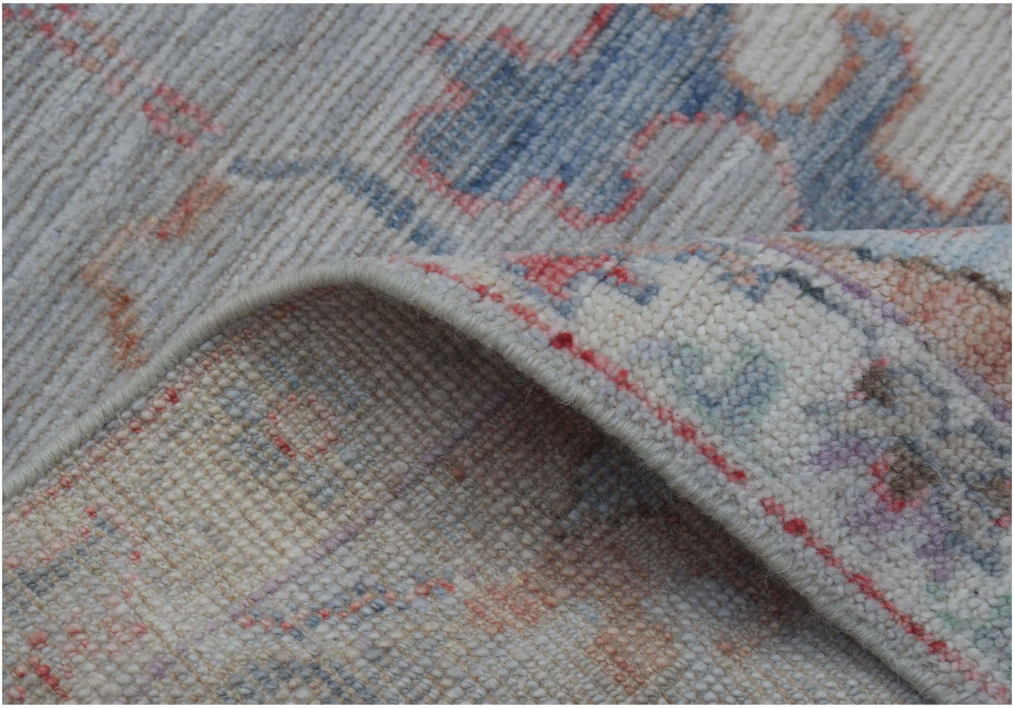 A close-up of a handmade wool Oushak runner featuring a traditional pattern in soft pastel tones.