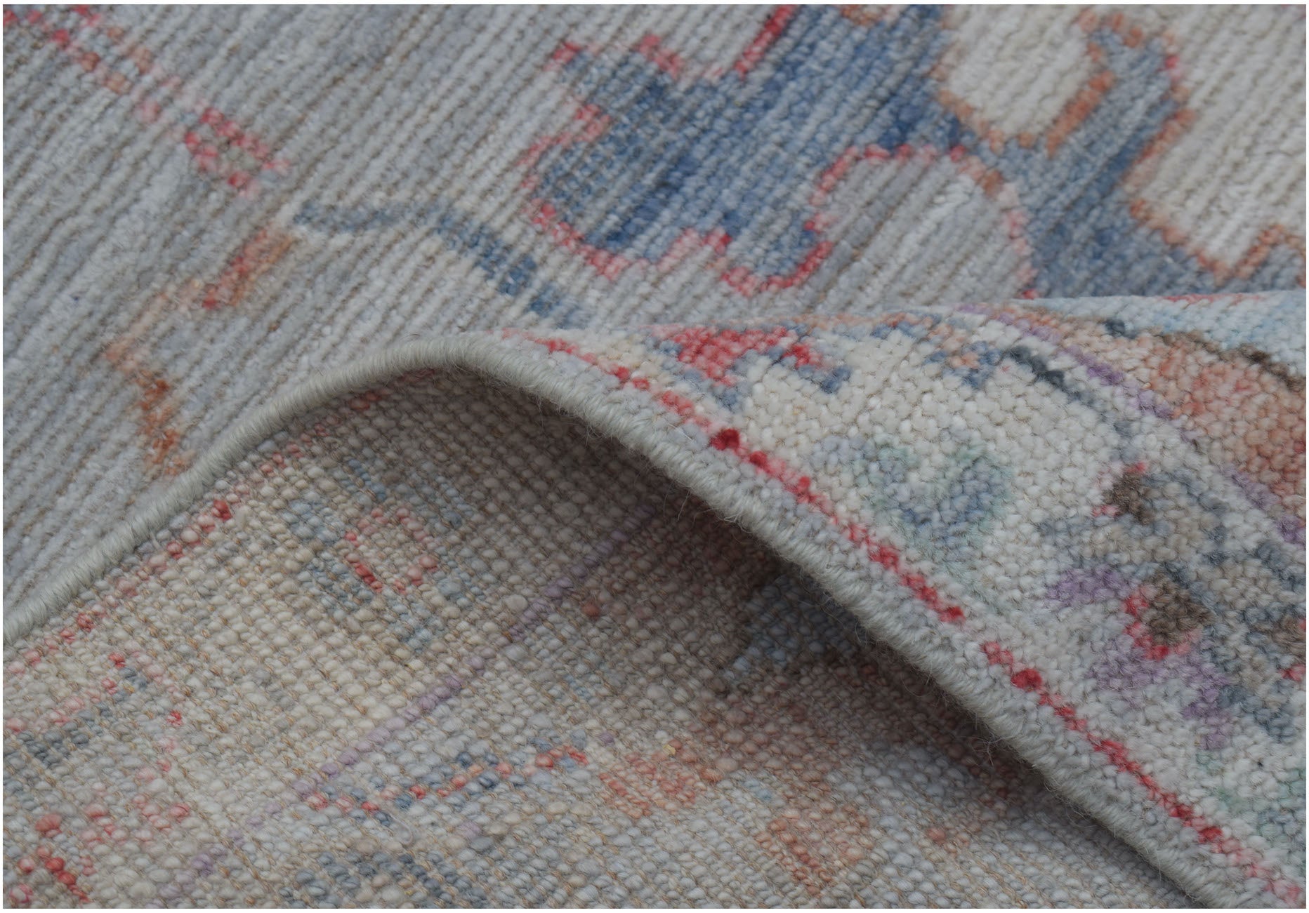 A close-up of a handmade wool Oushak runner featuring a traditional pattern in soft pastel tones.