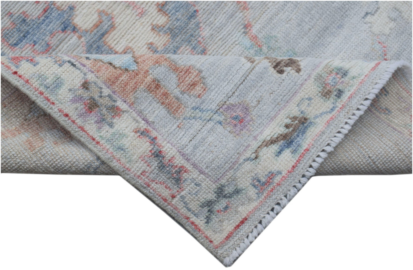 A handmade Afghan Oushak runner featuring a traditional pattern in soft blue, pink, and cream tones.