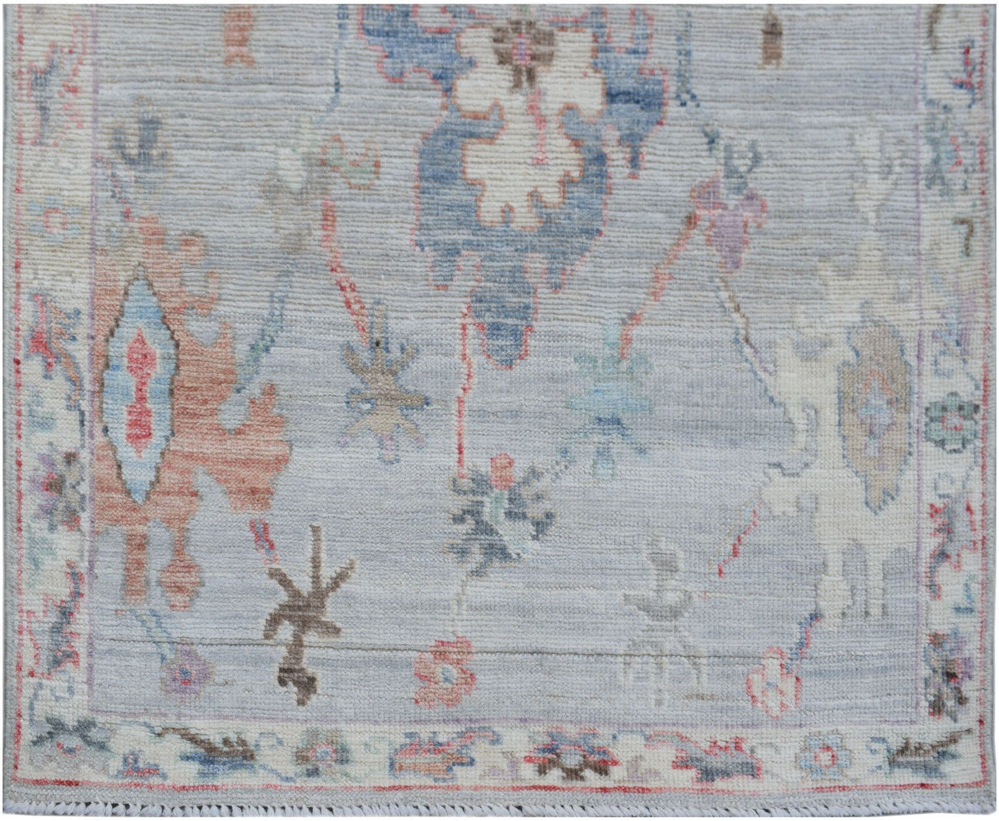 A handmade Afghan Oushak runner featuring a traditional spreading pattern in soft blue tones.