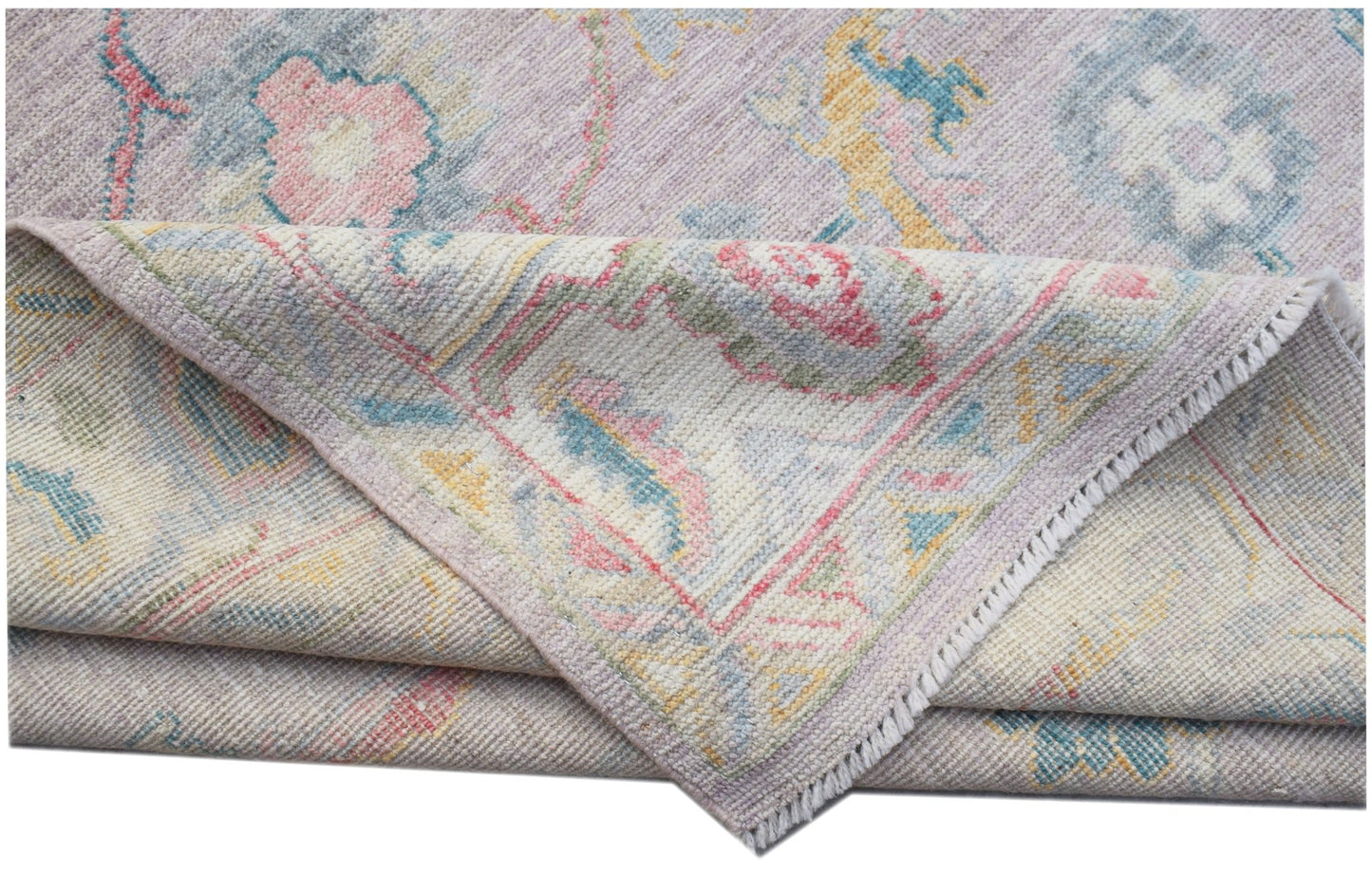 A handmade Afghan Oushak rug featuring a traditional floral pattern in soft pastel tones.