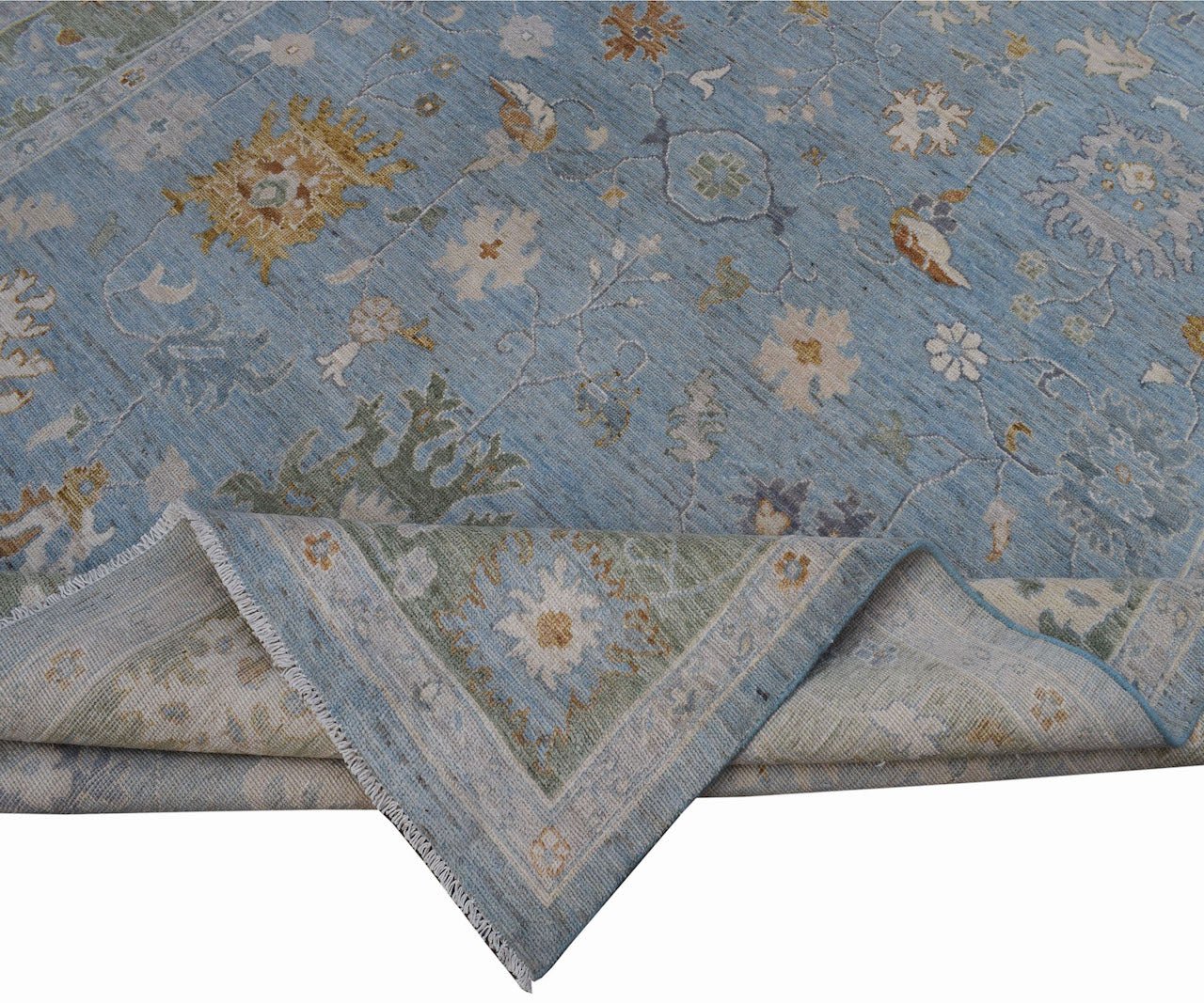 A handmade Afghan Oushak rug featuring a traditional floral pattern in shades of blue and cream.