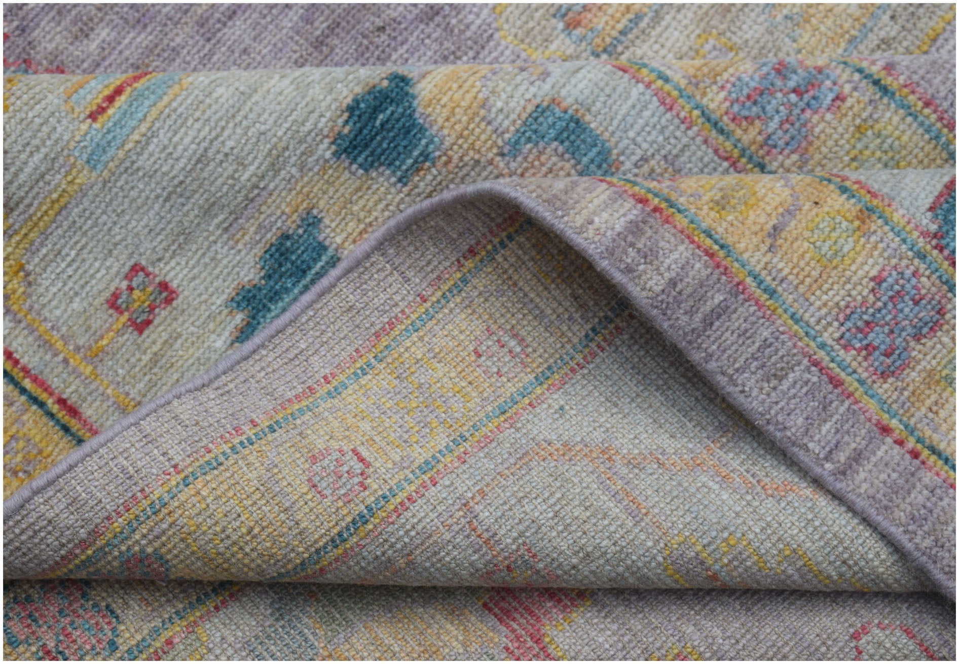 A handmade Afghan Oushak rug featuring a traditional pattern in soft pastel tones.