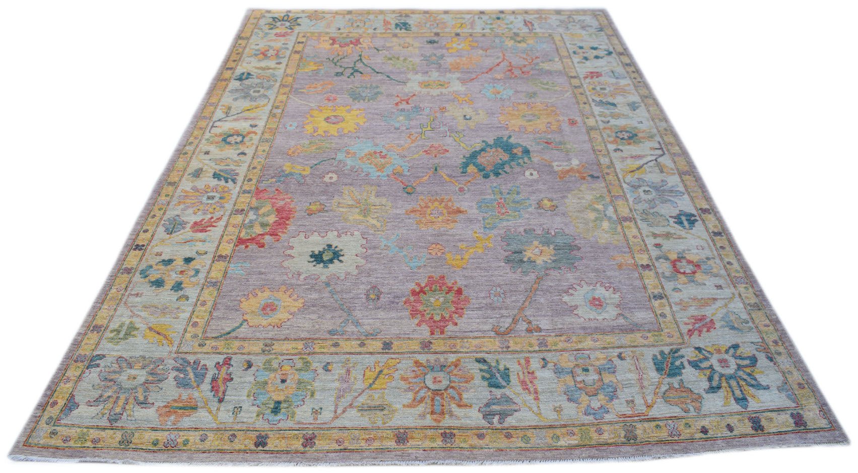 A handmade Afghan Oushak rug featuring a traditional floral pattern in a soft purple colorway.