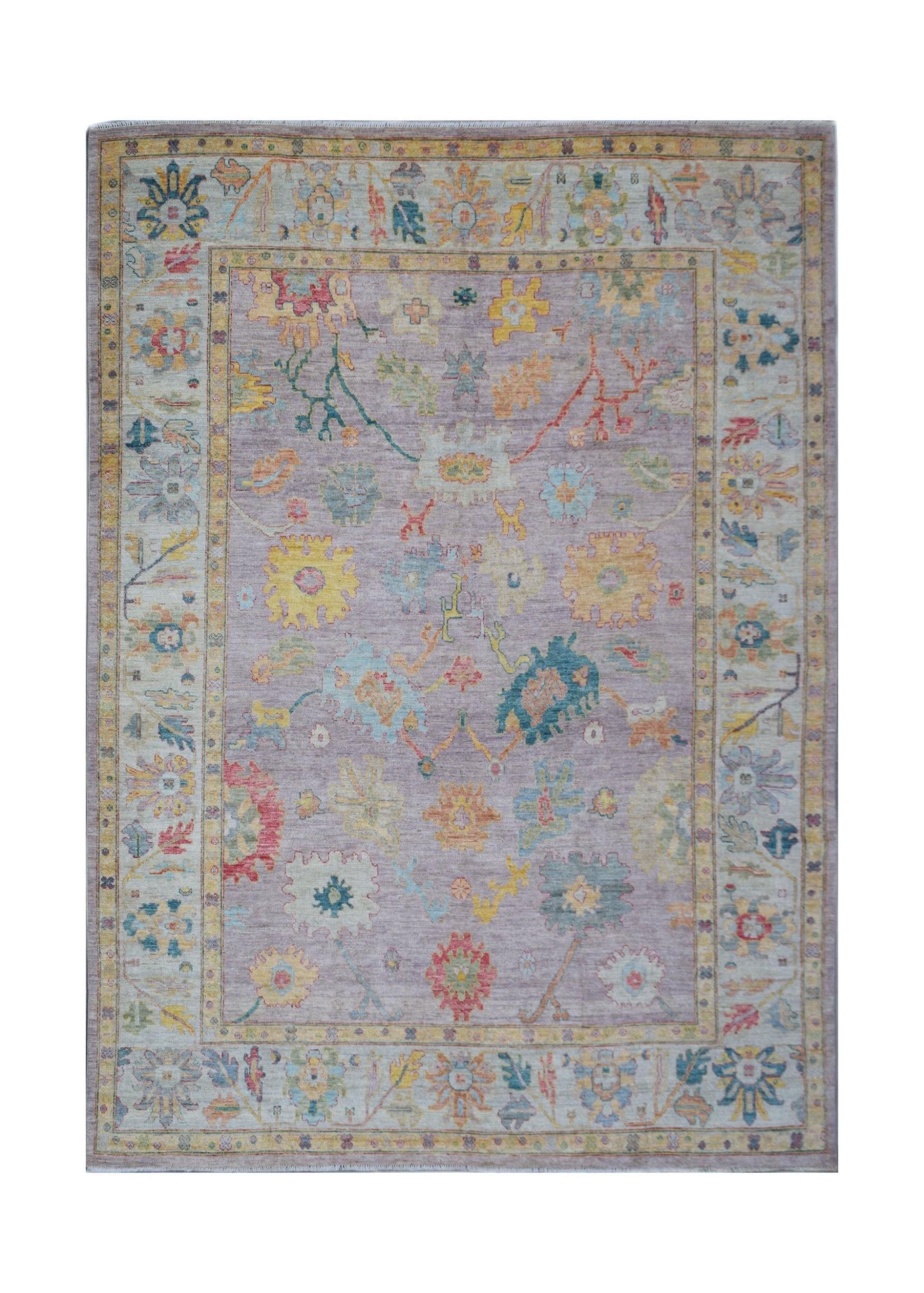 A handmade Afghan Oushak rug featuring a traditional floral pattern in a soft lavender colorway.
