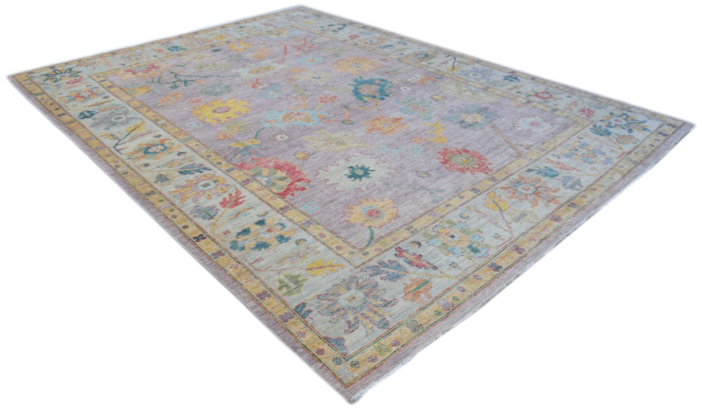 A handmade Afghan Oushak rug featuring a traditional floral pattern in soft, muted colors.