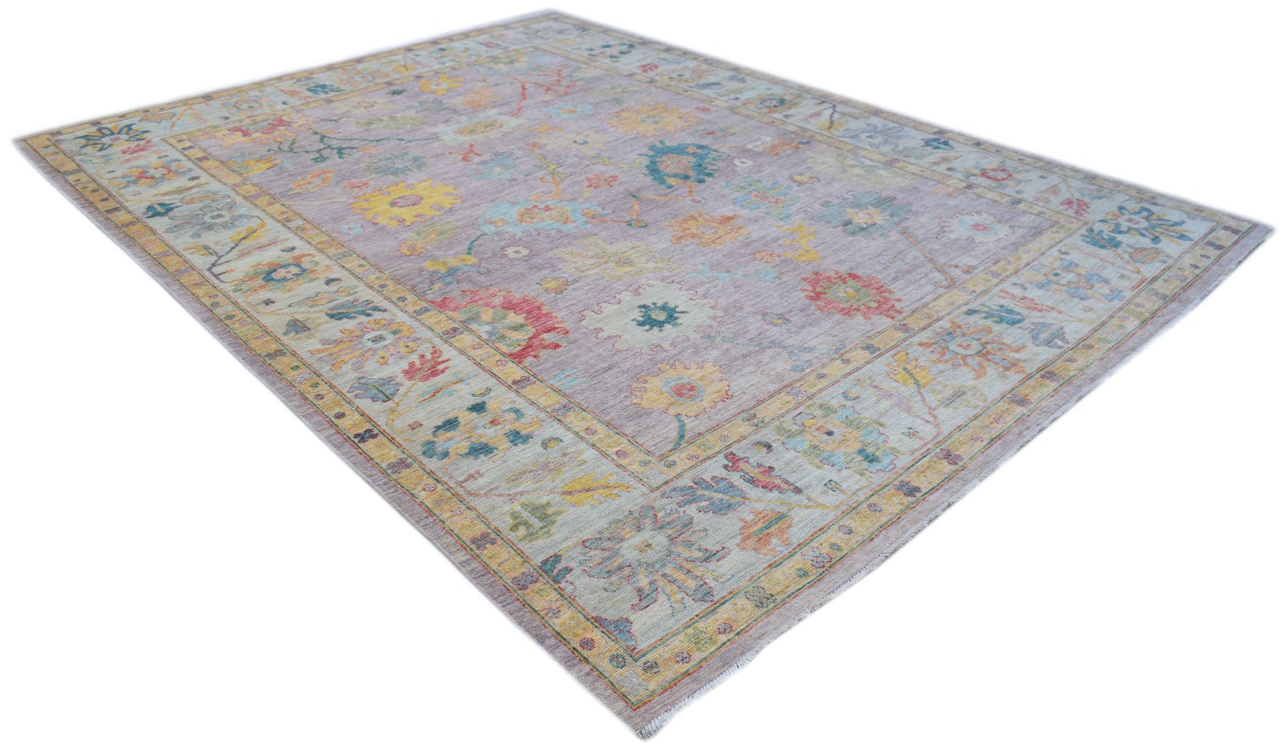 A handmade Afghan Oushak rug featuring a traditional floral pattern in soft, muted colors.