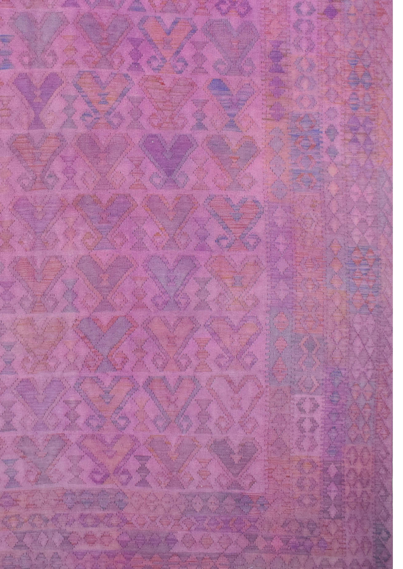 A handmade Afghan Maimana kilim rug featuring a repeating geometric pattern in shades of pink.