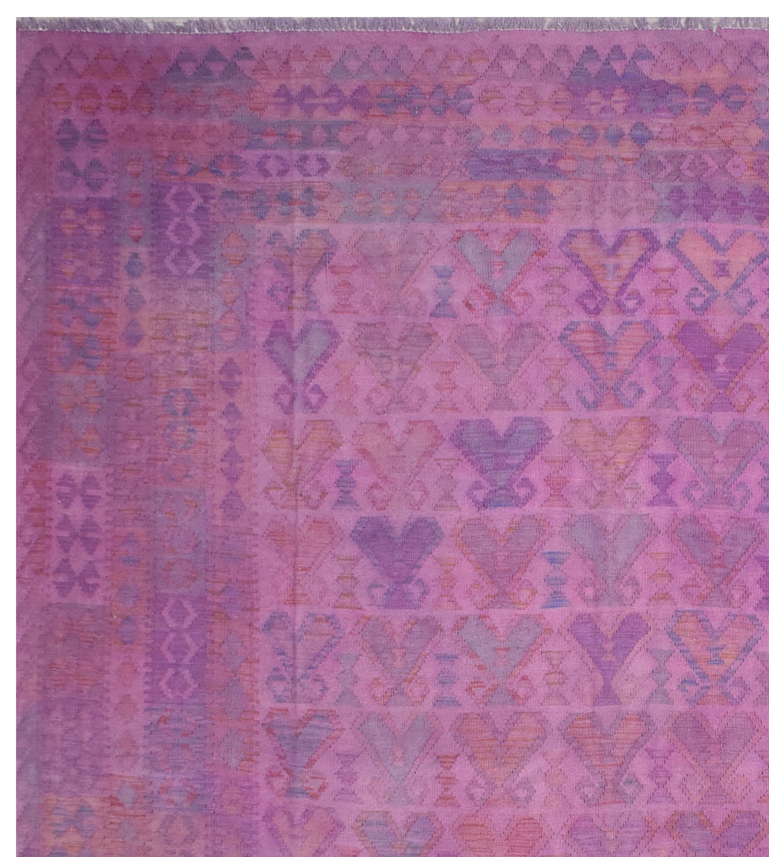 A handmade Afghan Maiamana kilim rug featuring a geometric pattern in shades of purple and pink.