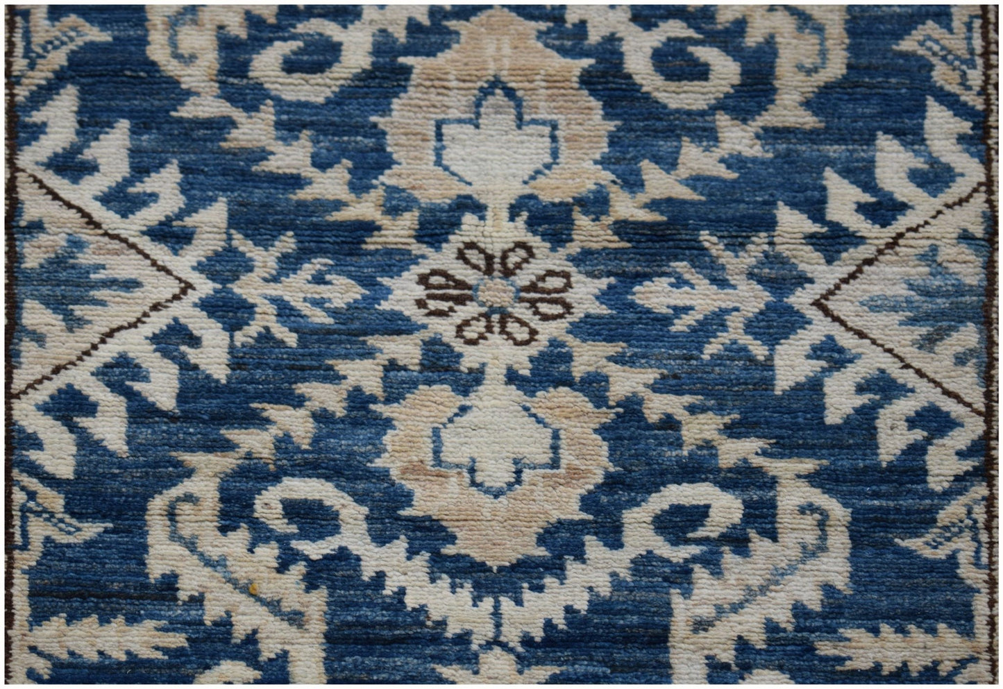 A handmade Afghan Super Kazakh runner featuring a traditional blue and cream geometric floral pattern.