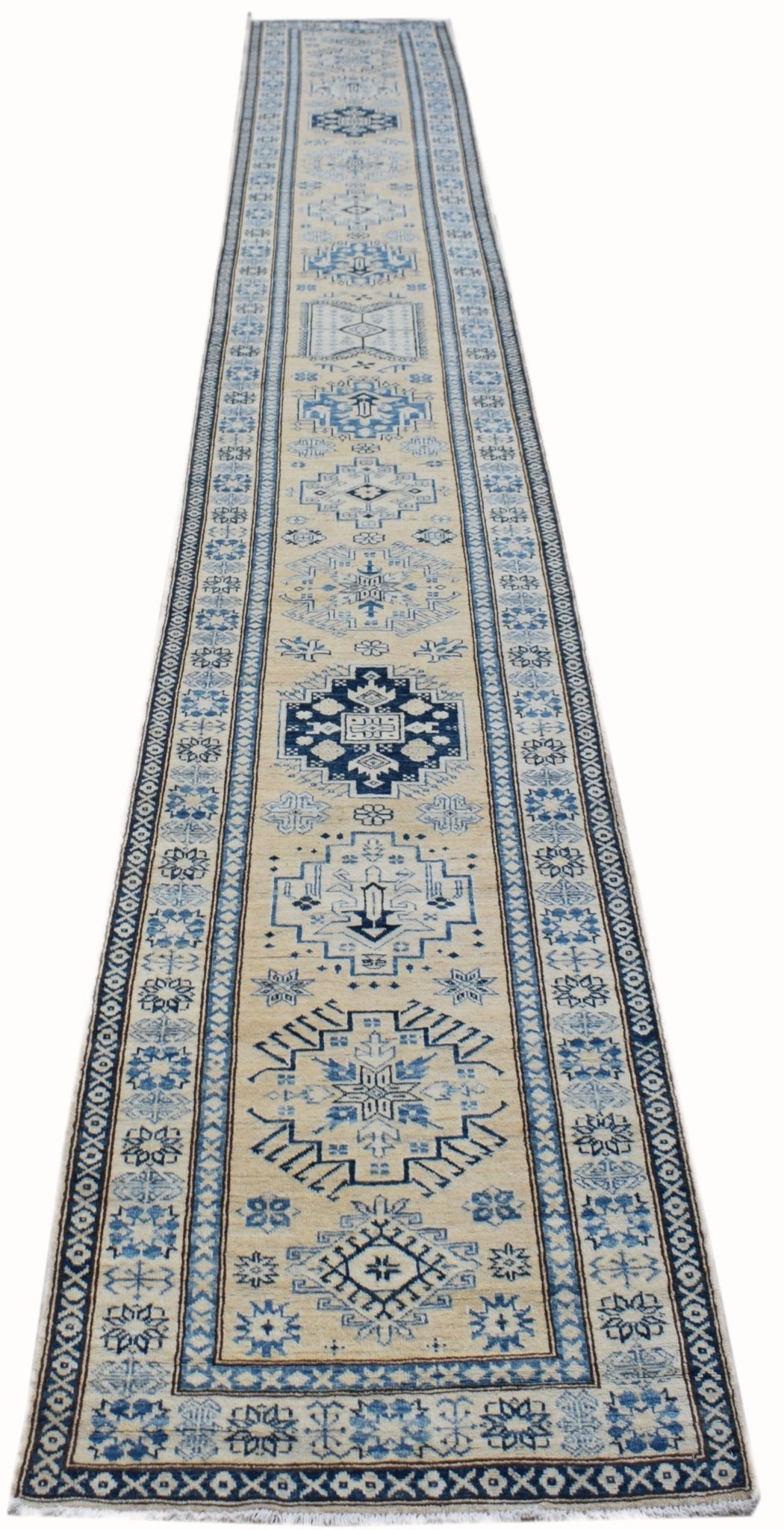 A long, handmade Afghan Super Kazakh runner rug featuring traditional blue geometric motifs on a cream background.