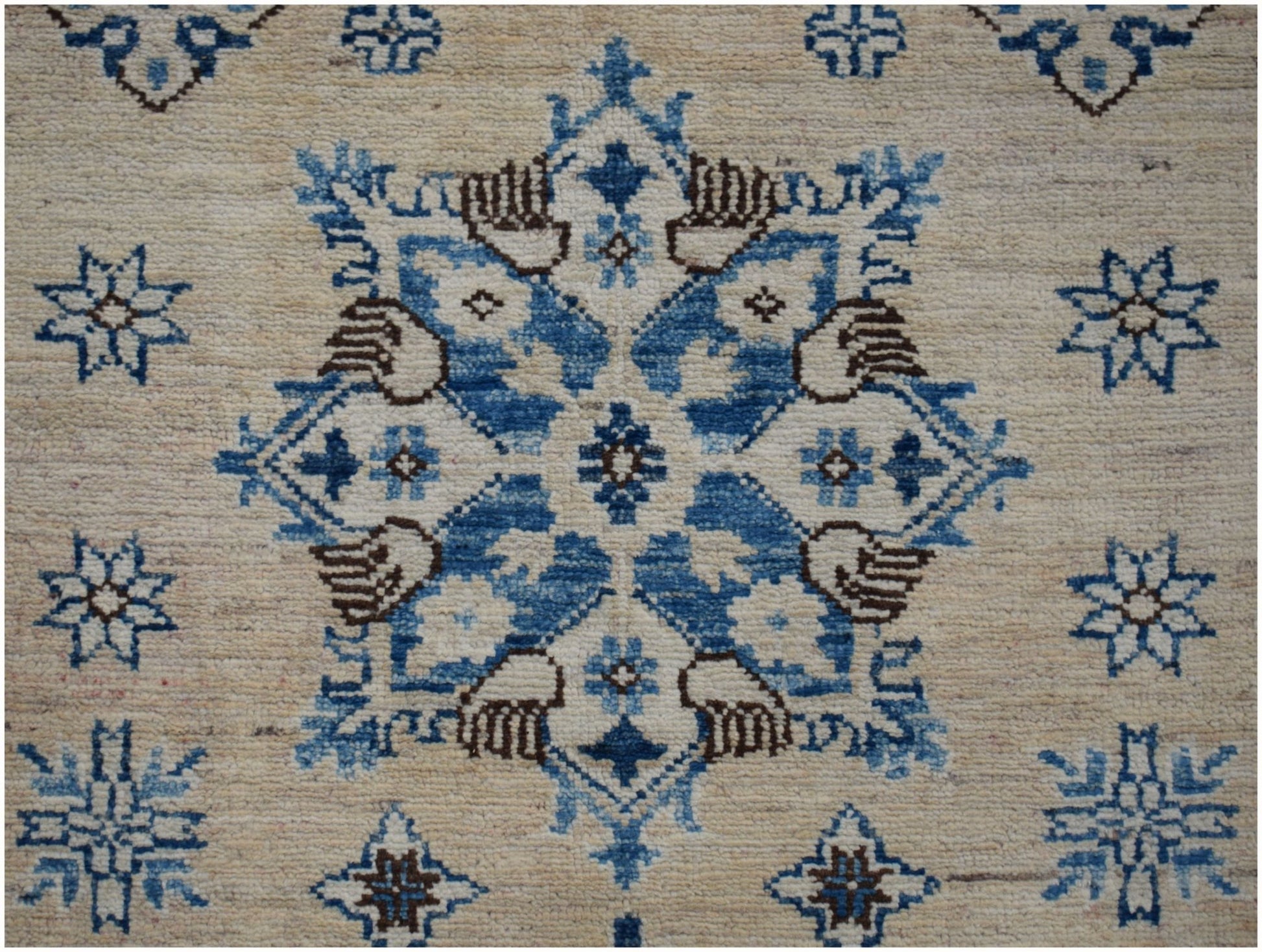 Handmade Afghan Super Kazakh runner featuring a central blue and brown floral medallion on beige.