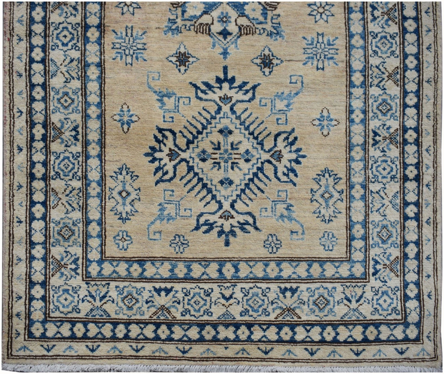 Handmade Afghan Super Kazakh runner rug featuring a blue geometric medallion on a beige field.